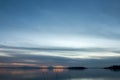 Beautiful view of Trasimeno lake Umbria, Italy at dusk, with blue and orange tones and moon in the sky Royalty Free Stock Photo