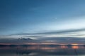 Beautiful view of Trasimeno lake Umbria, Italy at dusk, with blue and orange tones and moon in the sky Royalty Free Stock Photo