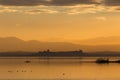 Beautiful view of Trasimeno lake Umbria, Italy at sunset, with orange tones, birds on water, a man on a canoe and Royalty Free Stock Photo