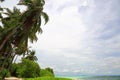 Beautiful view of tropical nature landscape. White sand beach and green palm trees on turquoise water and blue sky Royalty Free Stock Photo