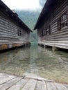 A beautiful view between two boat houses on the clear water and mountains Royalty Free Stock Photo