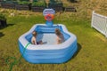 Beautiful view of two boys in inflatable outdoor swimming pool playing water basketball on sunny summer day. Royalty Free Stock Photo