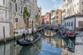 Beautiful view of a typical venetian canal, Venice, Italy, with a couple on a gondola, taking pictures and making video Royalty Free Stock Photo