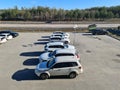 Beautiful view of vehicles on parking place on green forest trees and blue sky background.