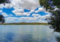 Beautiful view of the river, with lots of vegetation around, mountains and blue sky, located in a rural area. Royalty Free Stock Photo