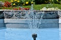 Beautiful view of a water fountain in the pool in flower garden on sunny day Royalty Free Stock Photo