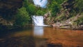 Beautiful view of the waterfall streaming down from the rocks into the river - great for wallpapers Royalty Free Stock Photo