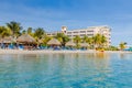 Beautiful view of white sand Curacao beach. Blue sunbeds under sun umbrellas on turquoise water and blue sky.