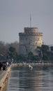 Beautiful view of the White Tower of Thessaloniki surrounded by trees in Greece behind the water