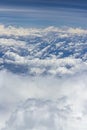 Beautiful view from window of plane flying over clouds. White clouds moving above the ground. Royalty Free Stock Photo