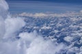 Beautiful view from window of plane flying over clouds. White clouds moving above the ground. Royalty Free Stock Photo