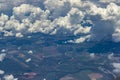 Beautiful view from window of plane flying over clouds. White clouds moving above the ground. Royalty Free Stock Photo