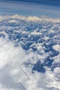 Beautiful view from window of plane flying over clouds. White clouds moving above the ground. Royalty Free Stock Photo