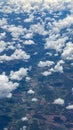 Beautiful view from window of plane flying over clouds. White clouds moving above the ground. Royalty Free Stock Photo