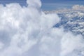 Beautiful view from window of plane flying over clouds. White clouds moving above the ground. Royalty Free Stock Photo