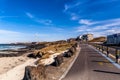 Beautiful view Woljeong Beach besides trunk road providing leading line at Jeju Island South Korea with white windmill at far left Royalty Free Stock Photo