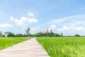 Beautiful view of wooden bridge with green field and blue sky. View of paddy field. Unmilled rice. Rice farm. Wallpaper, Royalty Free Stock Photo