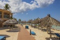 Beautiful view of wooden path between hotel buildings and sun umbrellas on beach along coastline. Royalty Free Stock Photo