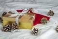 Beautiful view of a yellow box with a glittery golden cover and pine cones on a white bedsheet