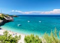 Beautiful view on Zakynthos stone and sand beach, stone rocks, swimming and toasting people on white sand beach, blue ultramarine