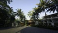 Beautiful villa against blue cloudy sky. Action. Palm trees and green grass. Royalty Free Stock Photo