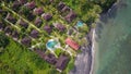 Beautiful villas, holiday bungalows, oceanfront vacation houses, swimming pool in luxury tourist resort in lush palm tree jungle