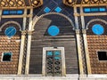 Beautiful vintage ancient old carved authentic door with windows with glass with a forged frame arches and patterns. background Royalty Free Stock Photo