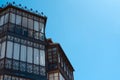 Beautiful vintage balconies made of black metal and wood against cyan blue sky in the old town downtown Segovia, Spain. Vintage