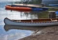 Beautiful vintage canoe on a lake shore on the surface of the glassy water