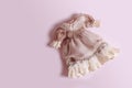 Beautiful vintage dress with ruffles for a doll on a pink background with copy space Royalty Free Stock Photo