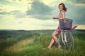 Beautiful vintage girl sitting next to bike, summer time Royalty Free Stock Photo