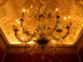 Beautiful vintage glass chandelier hangs from the gorgeous decorated ceiling