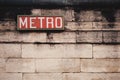An old metro sign on stone wall at subway station in paris, france