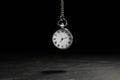 Beautiful vintage pocket watch with silver chain on black background above table. Hypnosis session Royalty Free Stock Photo