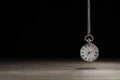 Beautiful vintage pocket watch with silver chain on black background above table, space for text. Hypnosis session Royalty Free Stock Photo