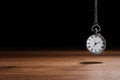 Beautiful vintage pocket watch with silver chain on black background above table, space for text. Hypnosis session Royalty Free Stock Photo