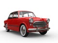 Beautiful vintage red compact car with white wall tires Royalty Free Stock Photo