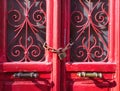 Beautiful vintage red wooden door detail under day light. Locked with chain and padlock Royalty Free Stock Photo