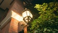 A beautiful vintage street lamp located on the wall of an old red brick house. The lantern illuminates the street at Royalty Free Stock Photo