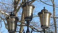 beautiful vintage street lamp with three plafonds against the blue sky