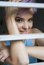 A beautiful violet short-haired woman behind a fence Royalty Free Stock Photo