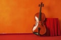 Beautiful violin leaning against a red wall. Ai generated