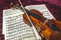 Beautiful violin and note sheets on purple background