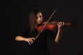 Beautiful Violinist Woman playing violin on black background Royalty Free Stock Photo
