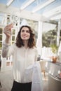 Beautiful waitress cleaning wine glass with napkin