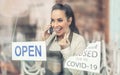 Beautiful waitress excitingly announces news on a phone about restaurant reopening as covid-19 restrictions ease Royalty Free Stock Photo