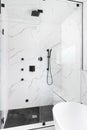 A walk-in shower with marble and circular tiles.