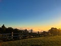 Beautiful warm sunset over a rural landscape lined with a wooden fence