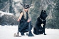 Warrior woman in image of viking with ax and horned helmet next to the big black dog in winter forest Royalty Free Stock Photo