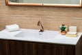 A beautiful washbasin with a copper tap and fittings. Marble sink, square led mirror, wooden cabinet Royalty Free Stock Photo
